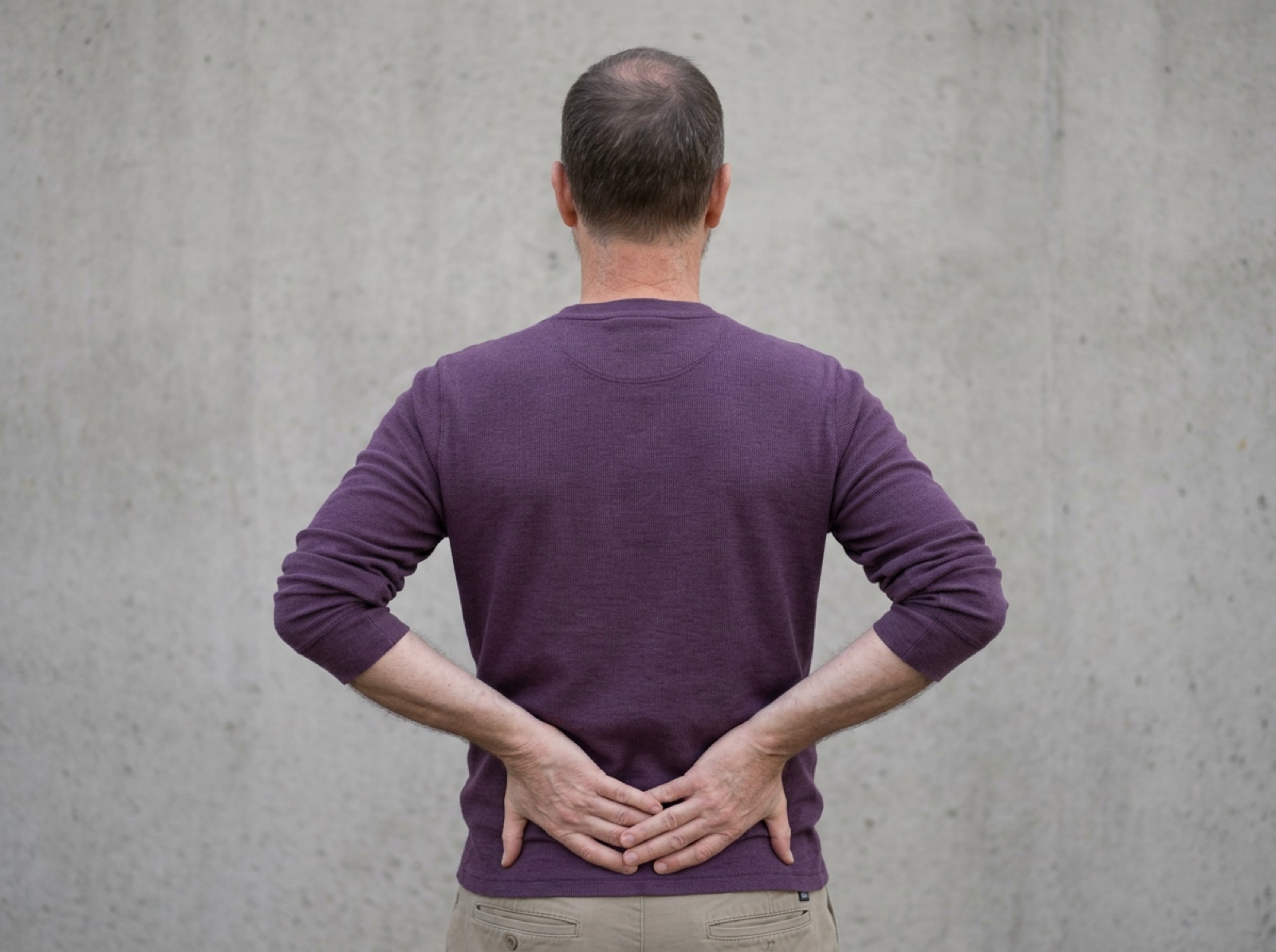 Hands supporting the lower back
